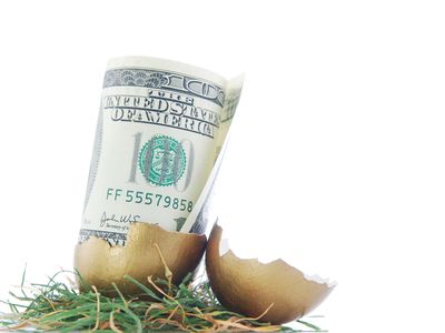 一个破裂的鸡蛋和一张代表退休基金的100美元钞票