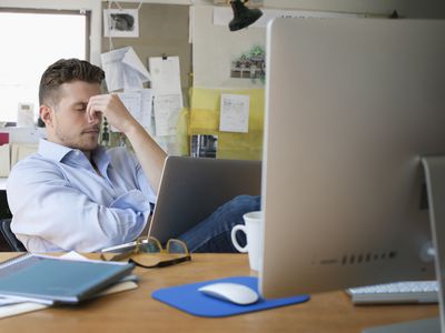 在办公室里，用笔记本电脑沮丧的白种人商人。