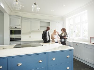 推销员或房地产经纪人在一对新厨房的家中展示了一对夫妇