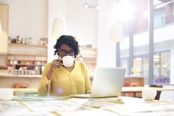 工作在书桌的创造性的妇女用咖啡“width=