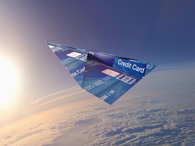 信用卡在大气中折成纸飞机＂width=