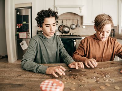 两个孩子数硬币放在厨房柜台上