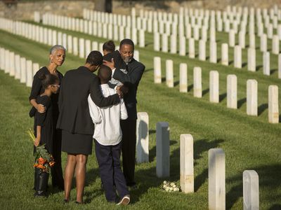多代家庭在军事公墓穿着黑色拥抱