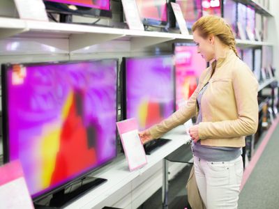 一个女人检查她可以购买的新电视上的规格。