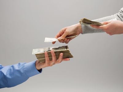 一个人的手在另一个人手里数着一叠钱的特写