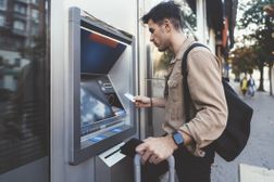 旅行者使用ATM。“width=