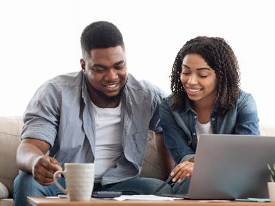 一个男人和一个女人在笔记本电脑前查看文件
