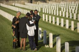 在军人公墓，几代人穿着黑色衣服拥抱在一起
