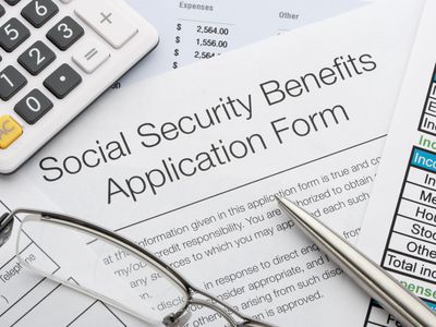 社会保障福利申请表用钢笔,眼镜,计算器和文档。