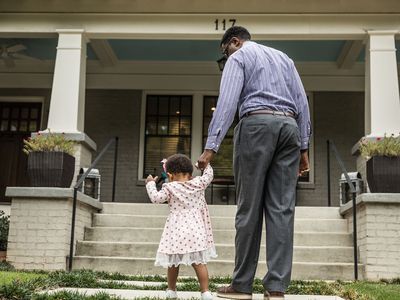 父亲和女儿走上台阶去房屋