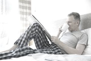 男人在床上喝咖啡