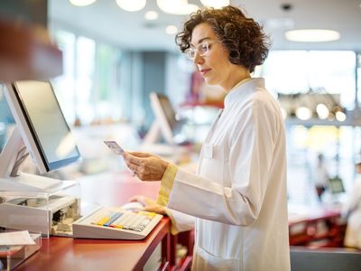 一个女人在商店结账时看一张信用卡。