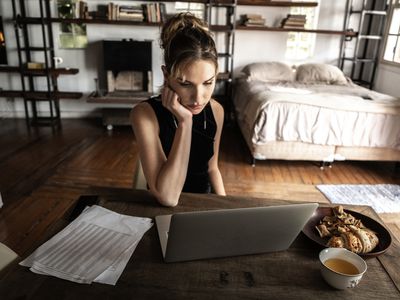 女人在家用笔记本电脑工作，吃点心喝咖啡＂width=