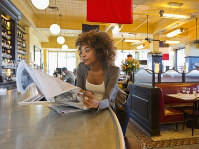 非裔美国人在咖啡馆阅读报纸