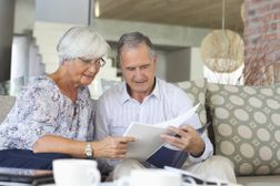 读在退休计划的资深夫妇，当坐他们的长沙发时