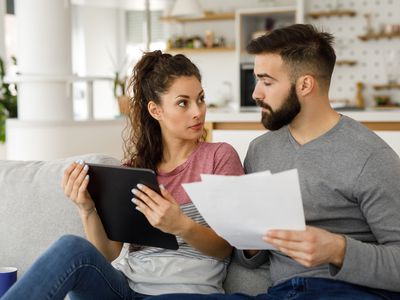 一对夫妇在家里用平板电脑一起查看他们的财务状况