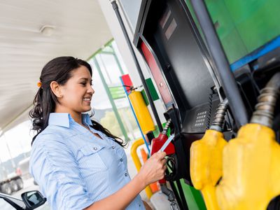 女人使用借记卡或信用卡在加油站泵付款