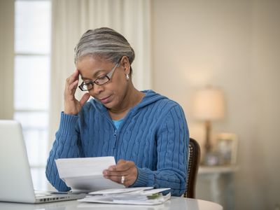 一位女士在查看她的401(k)计划文件时显得忧心忡忡。