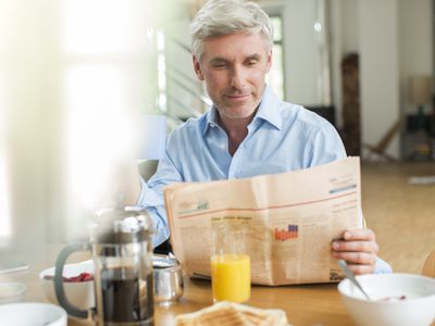 老人吃早餐和看报纸