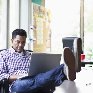 非裔美国商人用笔记本电脑工作