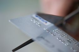 剪刀剪信用卡的特写镜头＂width=