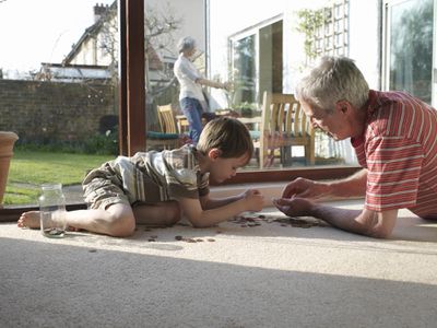 祖父和年轻孙子在地板上计算变化