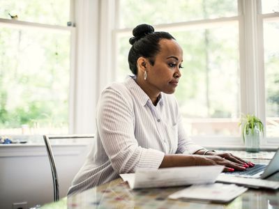 白色的妇女在一间膝上型计算机工作在家。