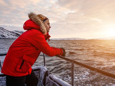 冬季在北极船上的红色外套的男人